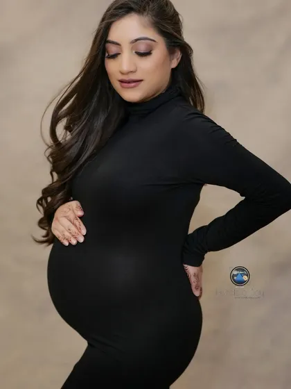 A classic profile portrait is a must have in any maternity gallery. This image focuses entirely on the mother to be, with a simple black turtleneck dress beautifully defining her pregnancy silhouette against a soft, neutral backdrop.