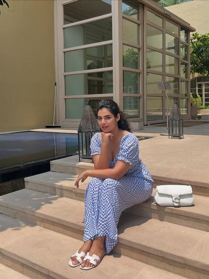 A similar pose, looking directly at the camera. This look is chic, relaxed, and perfect for a summer staycation.