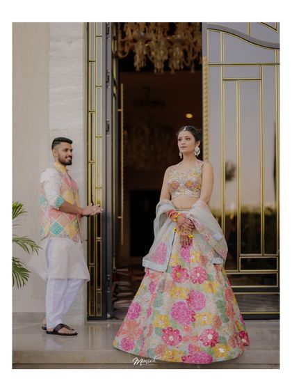 A playful portrait of the groom welcoming his bride at the entrance, a charming and chivalrous moment.