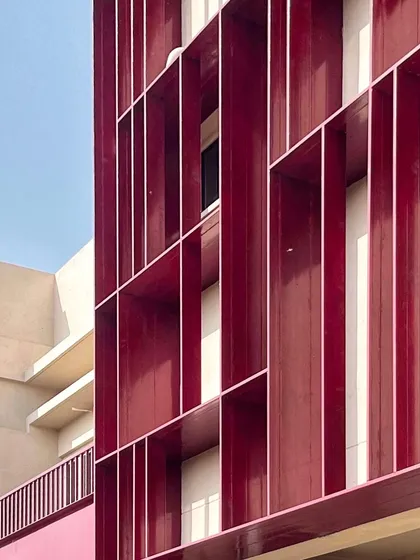A work-in-progress shot of the facade at the SMBV school. These deep red fins aren't just for looks; they are a key part of our sun-shading solution, designed to block harsh sunlight and help keep the classrooms cool.
