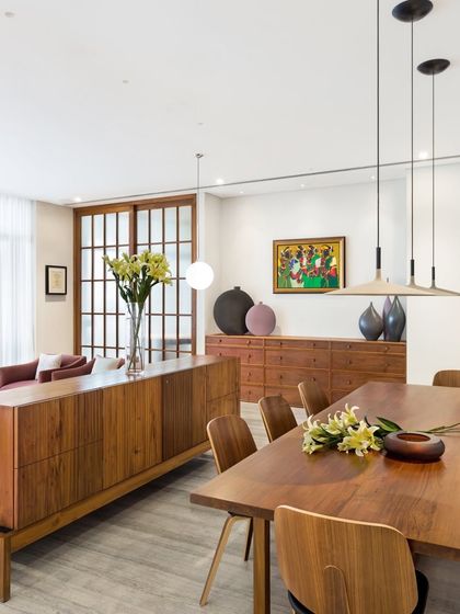 The dining and living space in the Limestone Residence is defined by its minimalist aesthetic. We used long, low-profile wooden credenzas to provide storage without visually cluttering the room, letting the beautiful furniture and art shine.