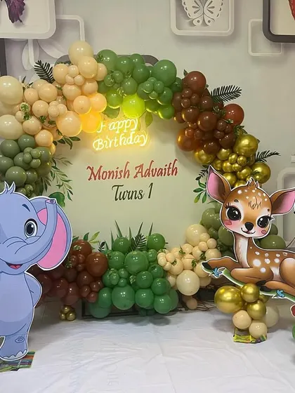 This jungle theme birthday decoration brings the wild indoors. It features a balloon arch in earthy tones, a personalized backdrop, and large cutouts of friendly cartoon animals like an elephant, deer, and toucan for the kids to enjoy.