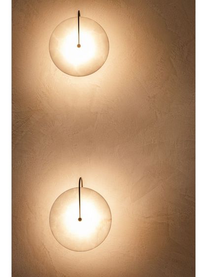 Wall sconces with a simple, elegant design provide soft, ambient lighting, enhancing the room's warm and inviting atmosphere.