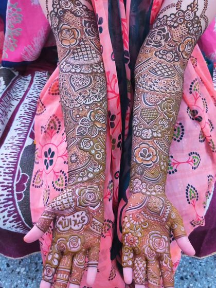 A detailed bridal design with the name 'Abdullah' written on the palm.