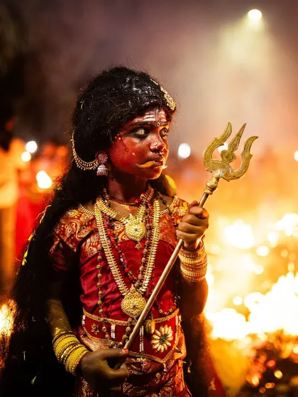 A young devotee embodying the spirit of goddess Kali during the Kulasai Dasara festival. This portrait, illuminated by the surrounding fires, captures the profound intersection of childhood innocence and ancient tradition in a single, powerful moment.