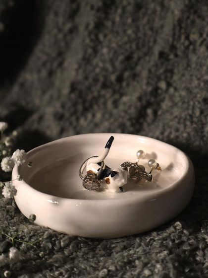 This calico cat ring holder is a beautiful and practical piece. The cat's tail is perfect for holding rings, and the dish can hold other small jewelry.