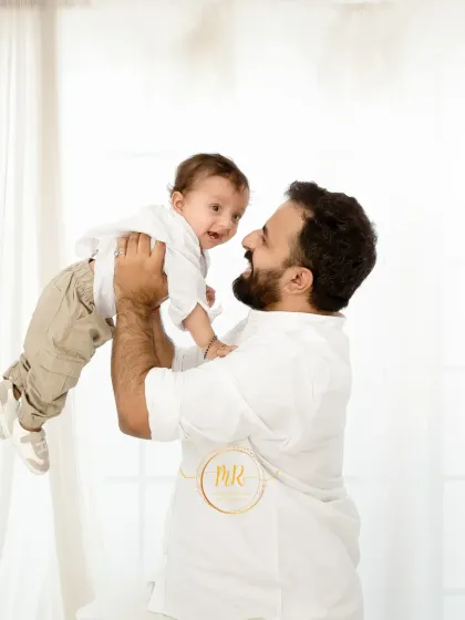 A father's joy is evident as he lifts his baby boy into the air. These playful interactions create wonderful, lasting memories.