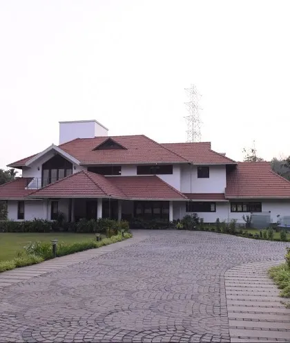 We also undertake large-scale projects like this estate house in Thrissur for Mr. Alex. The design balances a grand scale with traditional architectural forms, including sloping tiled roofs and deep verandas, creating a stately yet welcoming family home.