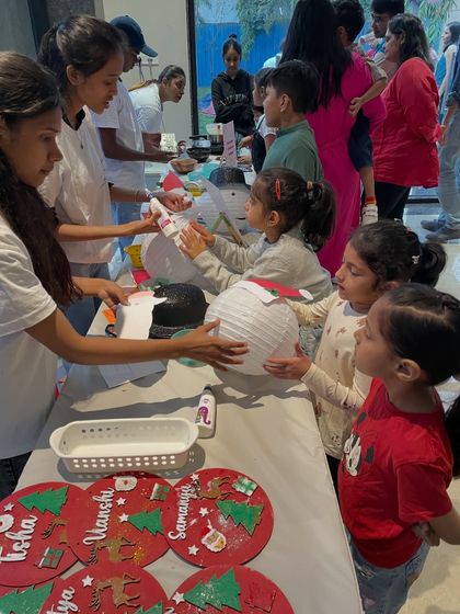 This is a typical scene at one of my workshops. Children are gathered around the table, fully engaged in making their own Christmas lanterns. My team and I are always there to guide and assist them.