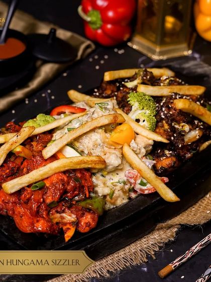 Get ready for a flavor explosion with our Chicken Hungama Sizzler. This platter features three different appetizers, like chili chicken and creamy chicken, served together on one sizzling plate.