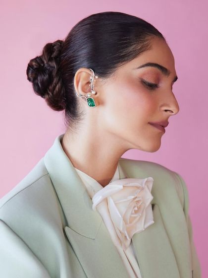 The intricate bun and statement ear crawler add a touch of classic glamour to this modern power suit.