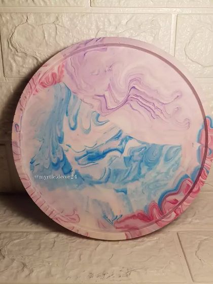 An XL round tray with a dreamy pastel marble effect, blending shades of pink, blue, and purple.