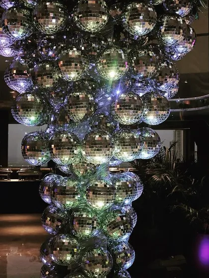 For a high-energy party vibe, I created this custom installation of disco balls, which catches the light and adds sparkle and fun to the dance floor area.