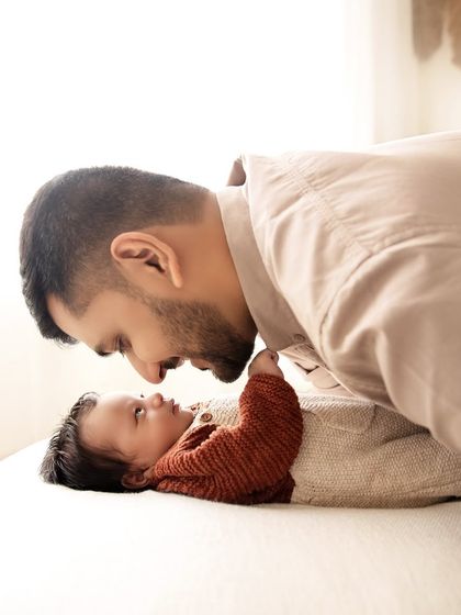 A father leans in close to his baby, a quiet conversation between just the two of them. These are the memories that last a lifetime.