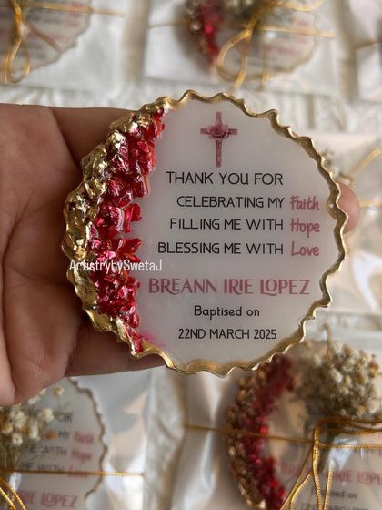 A close-up of one of the baptism keepsakes, showing the personalized text, date, and beautiful red and gold geode edge.
