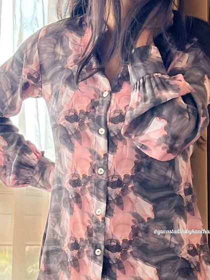 A detailed shot of our printed fine crepe shirt. The abstract pink and grey print and delicate sleeve details add a touch of elegance.