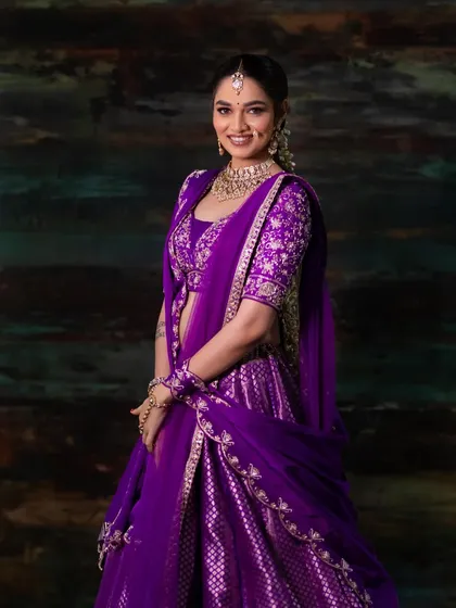 A smiling portrait of our model, looking absolutely radiant in this purple bridal creation.