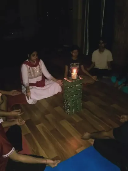 Students sit in a circle, focusing their gaze on the candle flame. This shared meditative experience builds a calm and focused energy within the group.