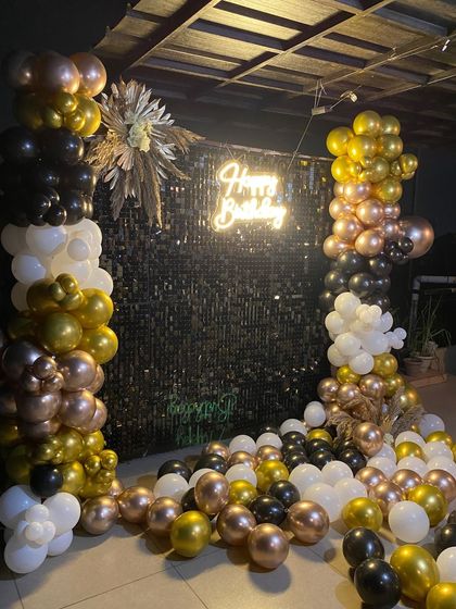 A full view of the stylish black and gold birthday photo booth.