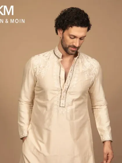 A closer view of the ivory kurta, highlighting the fine craftsmanship of the embroidery around the placket. This is the kind of detail that sets a bespoke garment apart.