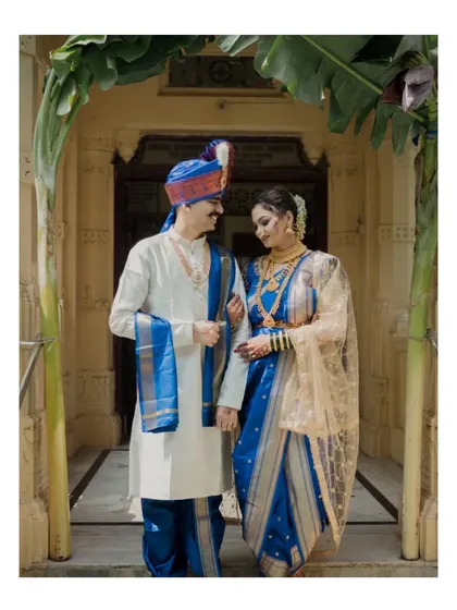 The couple framed by a traditional banana leaf archway. This shot captures them in a classic pose, symbolizing auspicious new beginnings in Maharashtrian culture.