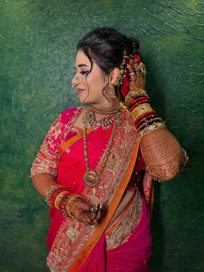 A close-up of a bride's soft glam makeup, paired with a traditional nath and a pink saree.