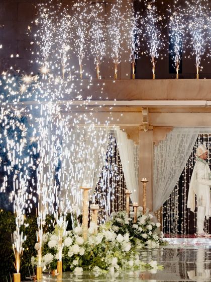The varmala ceremony, elevated with stunning special effects. The fountains of cold pyrotechnics were perfectly timed to create a magical and celebratory moment as the couple exchanged garlands.