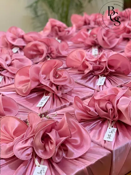 A large order of gifts wrapped in a beautiful shimmering pink organza. Each gift is finished with an elaborate, sculptural bow made from the same fabric, creating a sea of soft, luxurious presents.