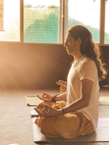 A sunbeam illuminates a student deep in meditation. In the quiet of the shala, you will find moments like these, where the outside world fades away and you can connect with your inner light.
