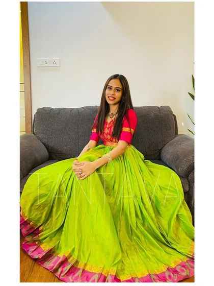 A client wanted a special outfit for her housewarming ceremony. We redesigned her vibrant green and pink saree into this beautiful dress, featuring a single-side pleat and a contrasting pink yoke.