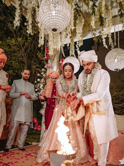 The couple making offerings to the sacred fire during their pheras, a key part of the Hindu wedding ritual.