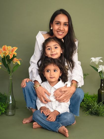 A mother sits with her two children, all sharing a happy and relaxed moment. The green and floral set for my Mother's Day minis created a perfect spring atmosphere.
