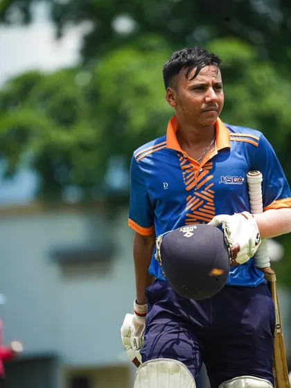 A young batsman walking off the field, helmet in hand, with a look of determination. Our tours provide invaluable experience, teaching players to adapt and perform in unfamiliar environments.