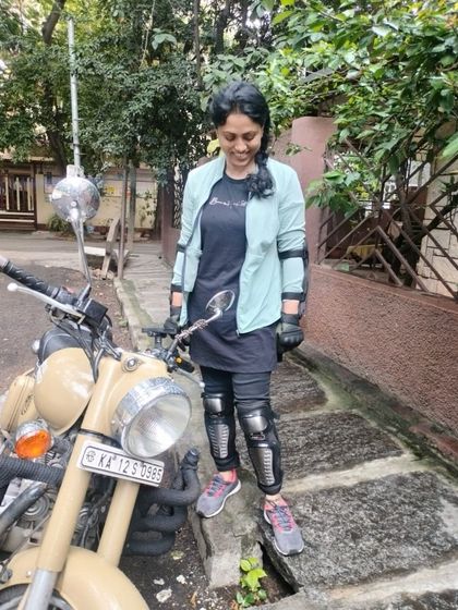 A graduate stands confidently with her bike. She is a statement of strength and a testament to what women can achieve.