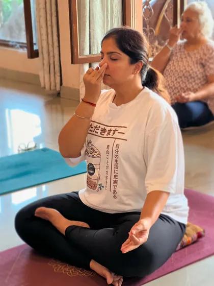 A student sits on a meditation cushion to support her pranayama practice. We guide our students on how to use props to make their practice more comfortable and effective.