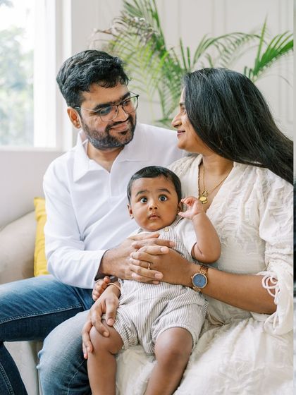 A family portrait from a seven-month milestone shoot. The baby's curious expression is the star of the show.