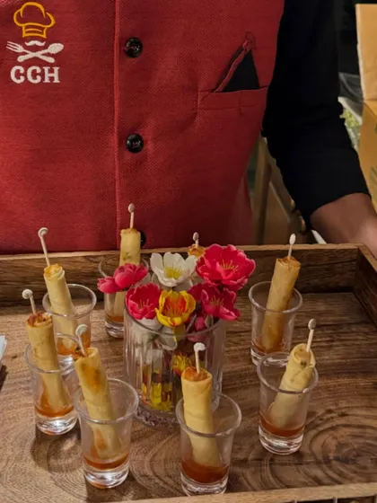 Crispy veg spring rolls served elegantly in shot glasses with a tangy sauce. This is a perfect example of how we blend great taste with creative food presentation.