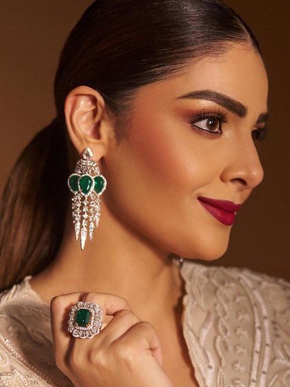 A close-up portrait focusing on the beautiful eye makeup and the flawless skin.