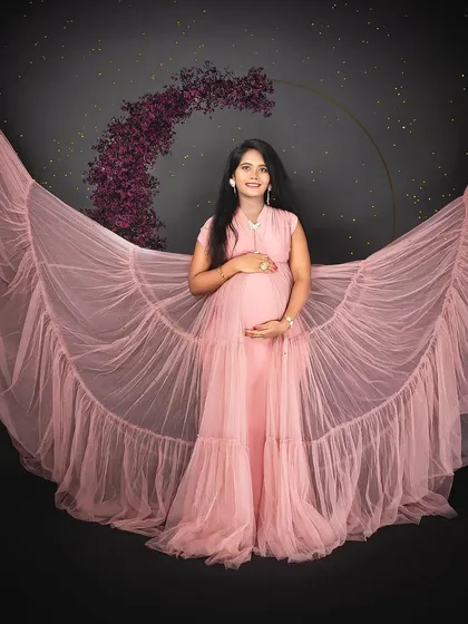We love getting creative with our studio setups. Here, we used flowing pink fabric to create ethereal "wings of motherhood," giving this solo maternity portrait a dreamy and magical feel against a starry backdrop.