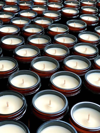 An army of amber jar candles, freshly poured and waiting for their labels. This is what a bulk white-label order looks like before the final branding step.