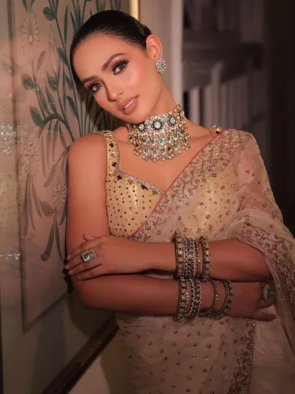 A full-length portrait of the golden saree look. The styling is sophisticated and timeless, perfect for a reception or festive event.