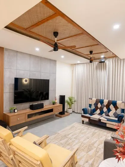 A wider view of the living room from image 16, showing the wooden slat partition and concrete-finish TV wall.