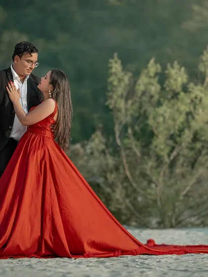 A quiet moment of connection amidst the grandeur. Even with a dramatic flowing gown, the focus remains on the couple's chemistry, captured against the natural, sandy riverbank.