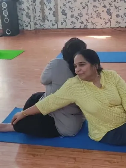 A beautiful partner stretch where one student performs a supported backbend while the other holds a seated twist. This demonstrates the creative and supportive ways we deepen our practice together.