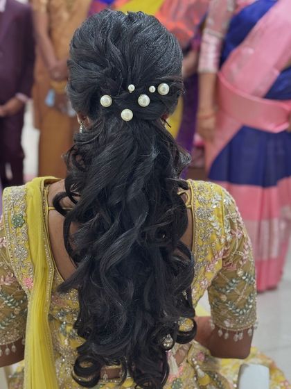 The modern and chic ponytail I created for Abi's reception. The style features soft waves and is adorned with elegant pearl accessories.