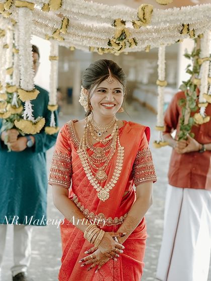 A happy, candid shot of a bride during her wedding procession. Her makeup is fresh and natural, designed to last through a long day of ceremonies.
