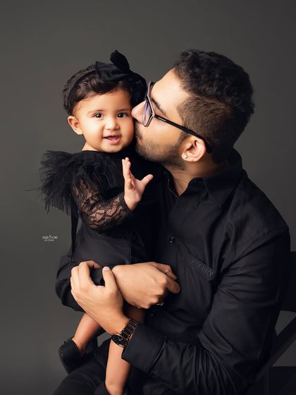 A father's gentle kiss for his baby girl. These quiet, tender moments are just as important to capture as the big smiles.