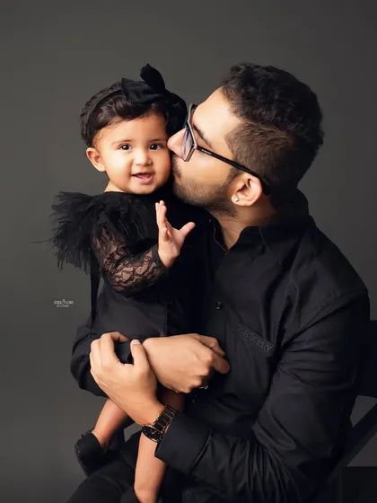 A father's gentle kiss for his baby girl. These quiet, tender moments are just as important to capture as the big smiles.