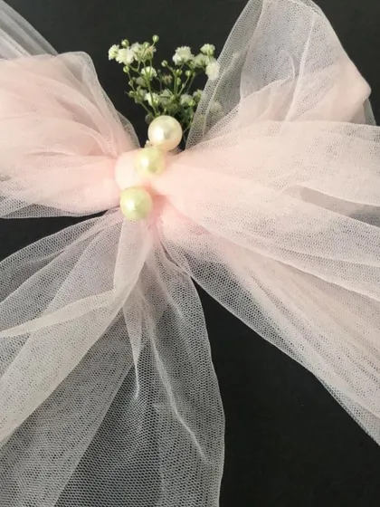 I believe luxury is found in the smallest details. This close-up shows the delicate finishing touches on one of my newborn gift hampers, featuring a hand-tied tulle bow accented with pearls and a sprig of fresh baby's breath.