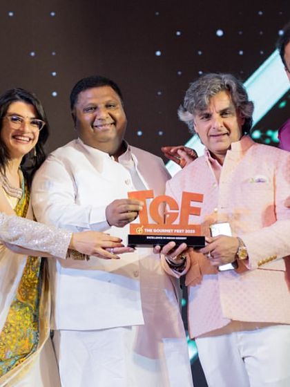 A close-up of our team holding the award for 'Excellence in Indian Dessert'. We are passionate about elevating Indian sweets, and this recognition means the world to us.